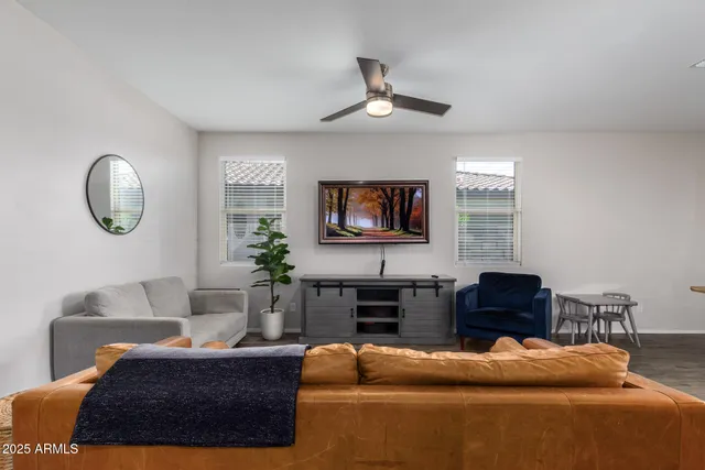 a living room with furniture a large window and a flat screen tv