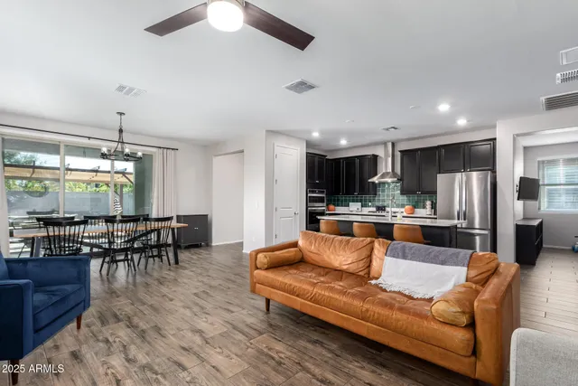 a living room with stainless steel appliances kitchen island granite countertop furniture and a dining table