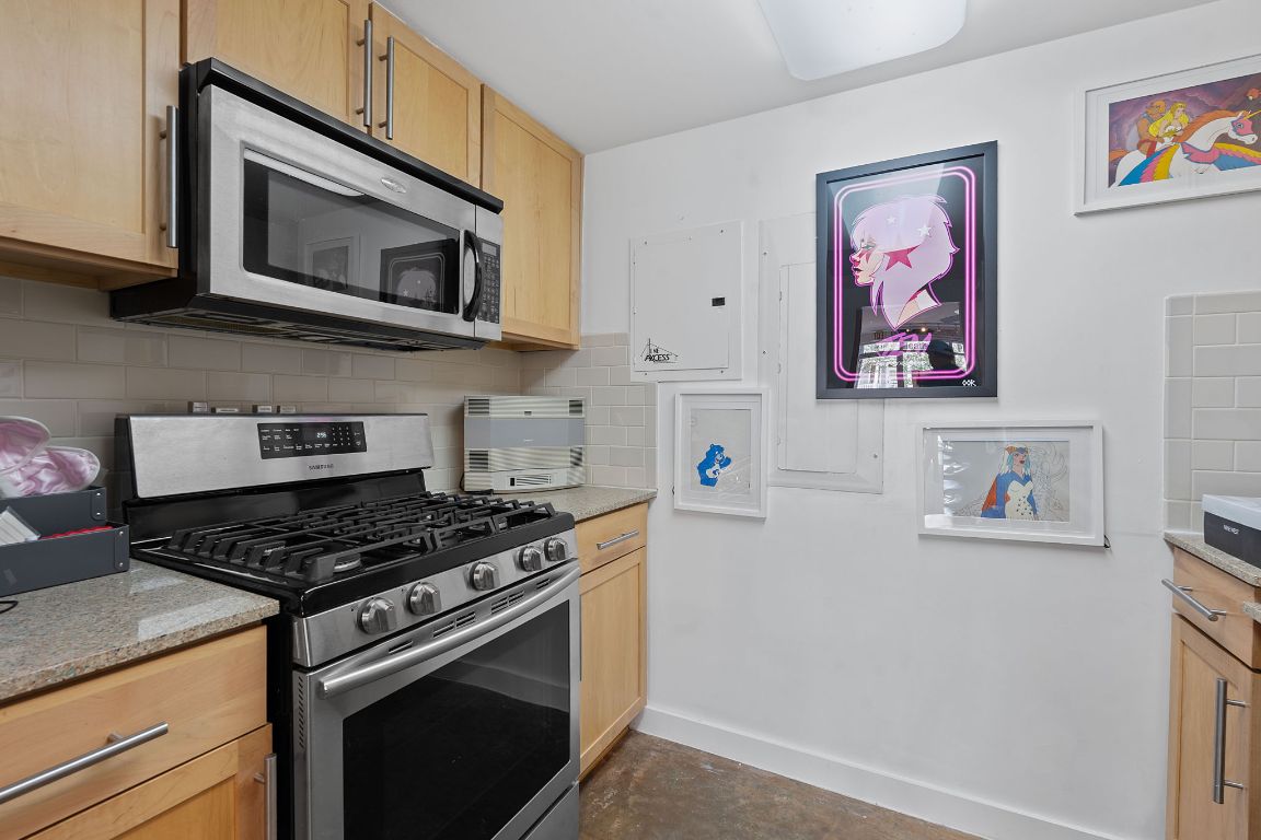 1601 East Cesar Chavez Street, Unit 104 Austin, TX 78702 - Photo 11 of 33 a kitchen with stainless steel appliances white cabinets and a stove top oven