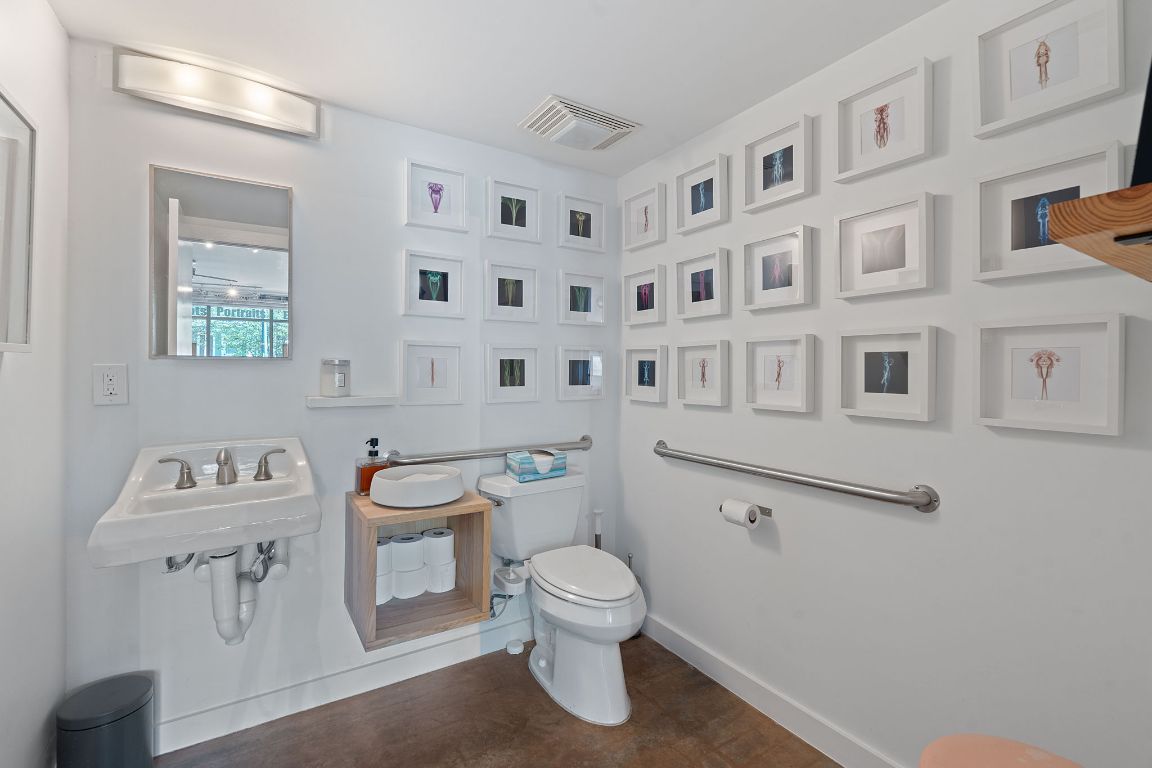 1601 East Cesar Chavez Street, Unit 104 Austin, TX 78702 - Photo 13 of 33 a bathroom with a toilet a sink and a mirror