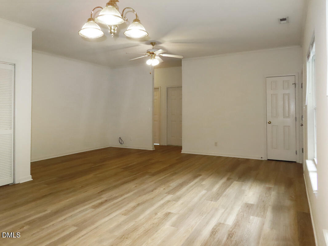 101 Rock Haven Road, Unit E500 Carrboro, NC 27510 - Photo 5 of 19 a view of an empty room with wooden floor and a ceiling fan