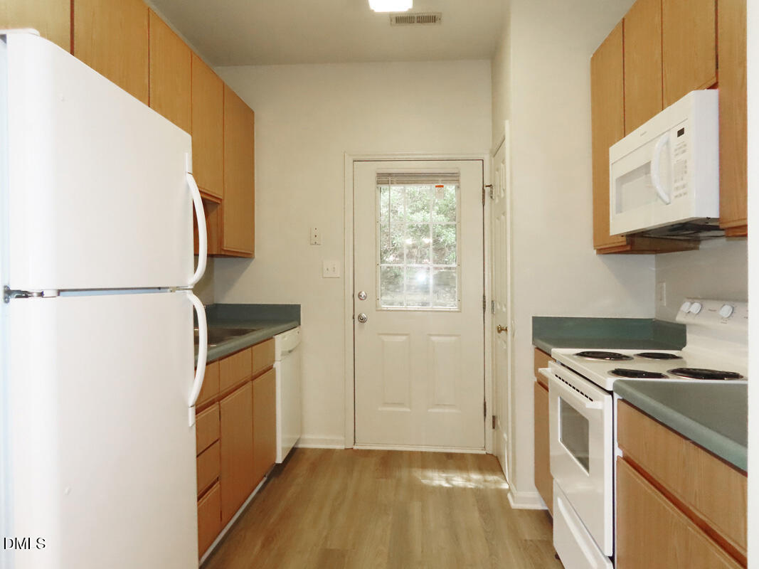 101 Rock Haven Road, Unit E500 Carrboro, NC 27510 - Photo 7 of 19 a kitchen with granite countertop a refrigerator and a stove top oven