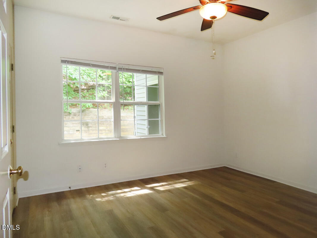 101 Rock Haven Road, Unit E500 Carrboro, NC 27510 - Photo 9 of 19 wooden floor in an empty room with a window