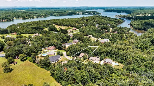 an aerial view of residential houses with outdoor space and trees