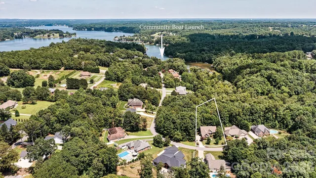 an aerial view of residential houses with outdoor space and trees