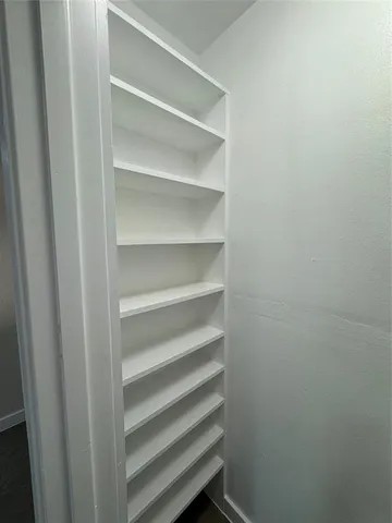 a view of walk in closet with empty racks