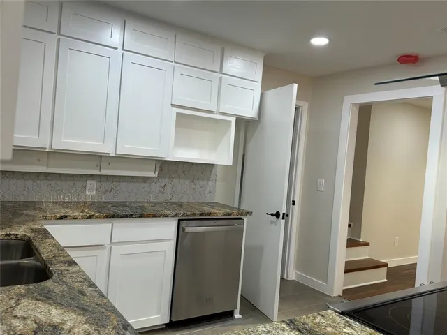 a kitchen with granite countertop white cabinets and white appliances
