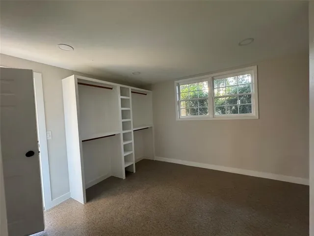 an empty room with windows and closet