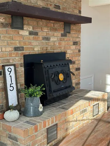 a room with a fireplace and potted plant