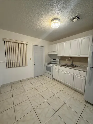 a kitchen with cabinets and window