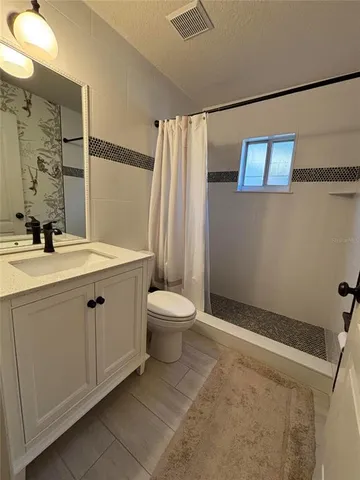 a bedroom with a bed a couch and a flat screen tv