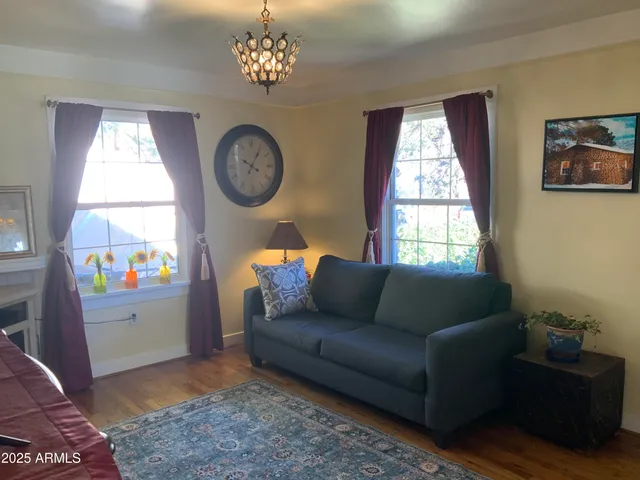 a living room with furniture a chandelier and a window