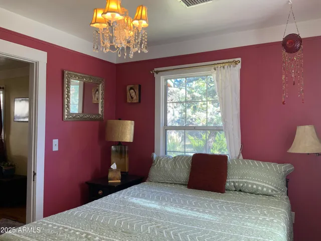 a bedroom with a bed and a chandelier