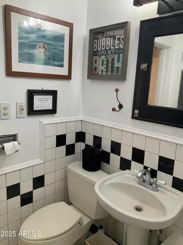 a bathroom with a toilet a sink and mirror