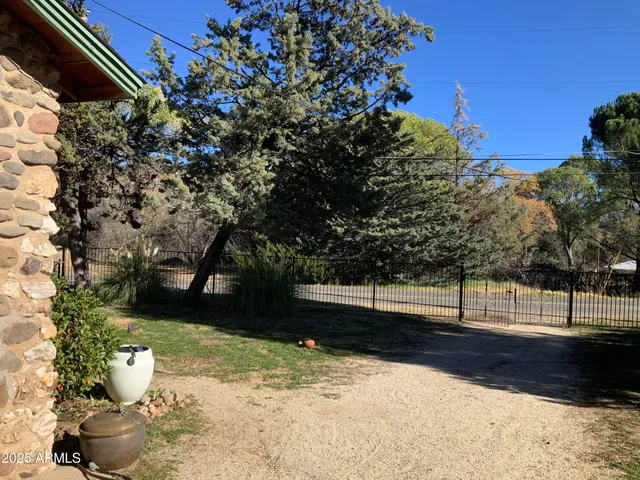 a view of a yard with wooden fence