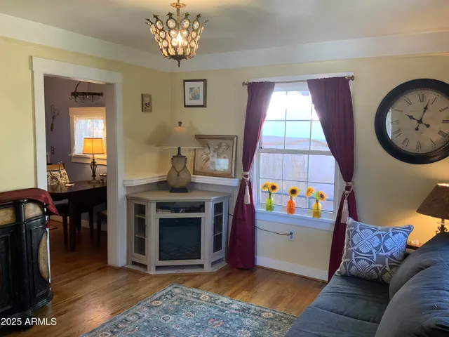a living room with furniture a fireplace and a chandelier