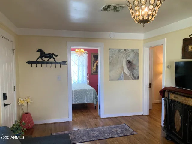 a view of a hallway with wooden floor and a potted plant