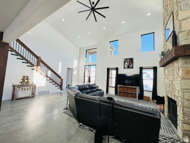 100 Whit Lane Georgetown, ID 83239 - Photo 18 of 76 Living area with a high ceiling, a stone fireplace, finished concrete flooring, recessed lighting, and a ceiling fan
