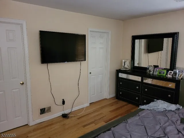 a bedroom with a bed and a flat tv screen on the table