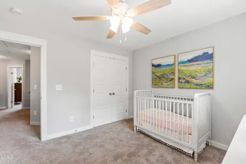 an empty room with windows and a ceiling fan