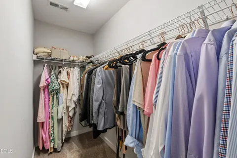 a view of walk in closet with clothes