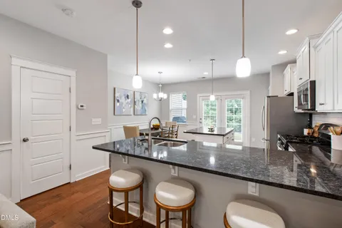 a kitchen with kitchen island granite countertop a sink a center island stainless steel appliances and cabinets