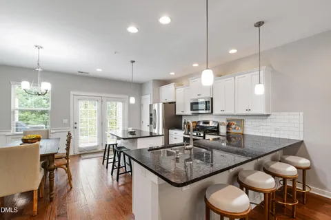 a kitchen with a table chairs stove and kitchen island
