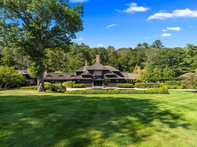 a view of a big house with a big yard and large trees