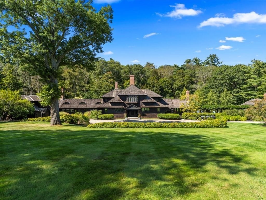a view of a big house with a big yard and large trees