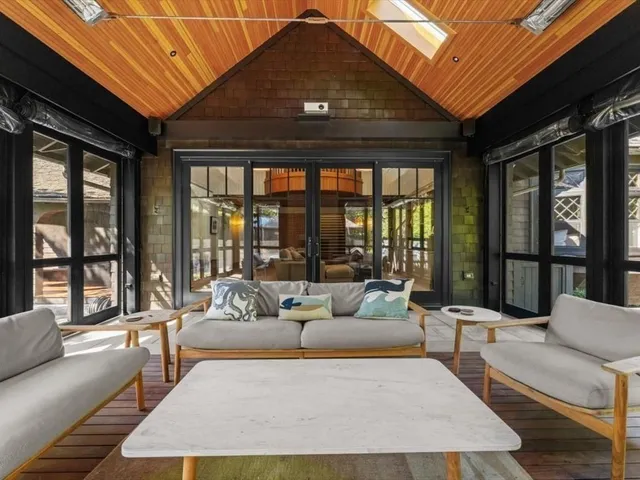 a living room with furniture and floor to ceiling windows