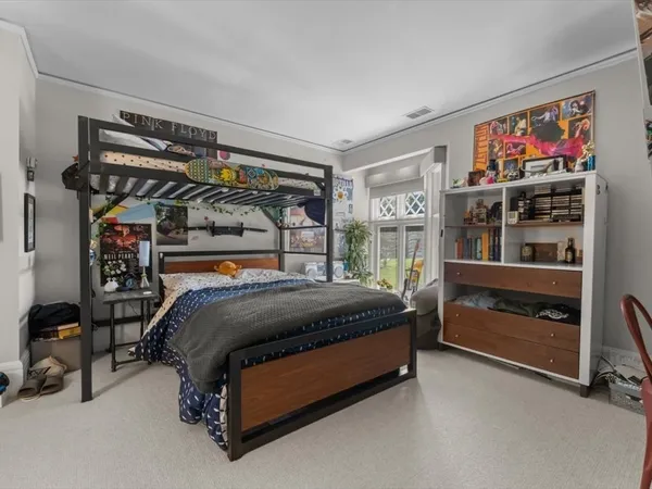 a bed sitting in a bedroom next to a window