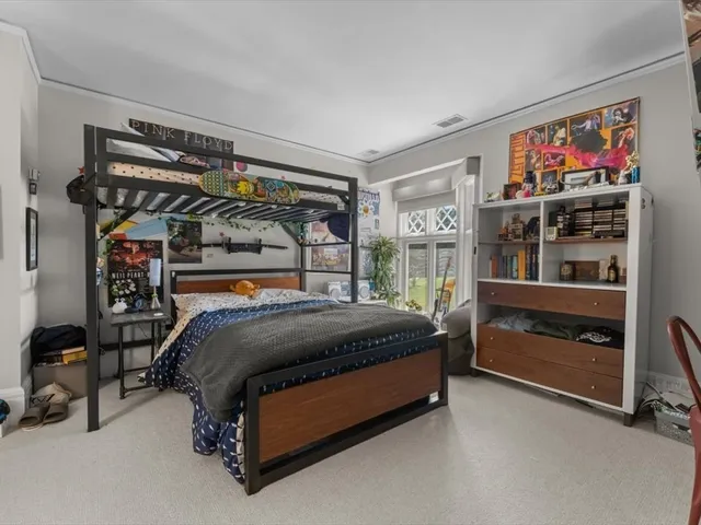 a bed sitting in a bedroom next to a window