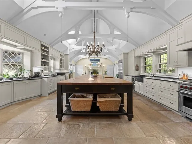 a living room with stainless steel appliances kitchen island granite countertop furniture and a chandelier