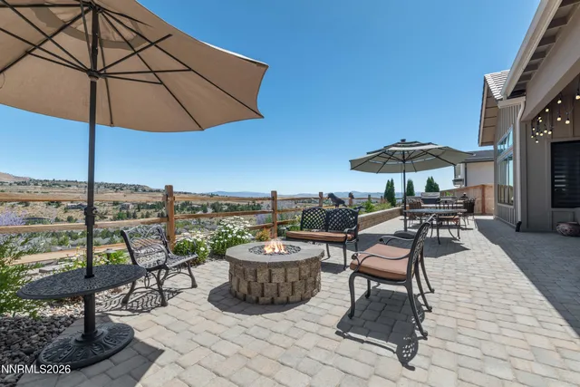 a patio with a table and chairs under an umbrella