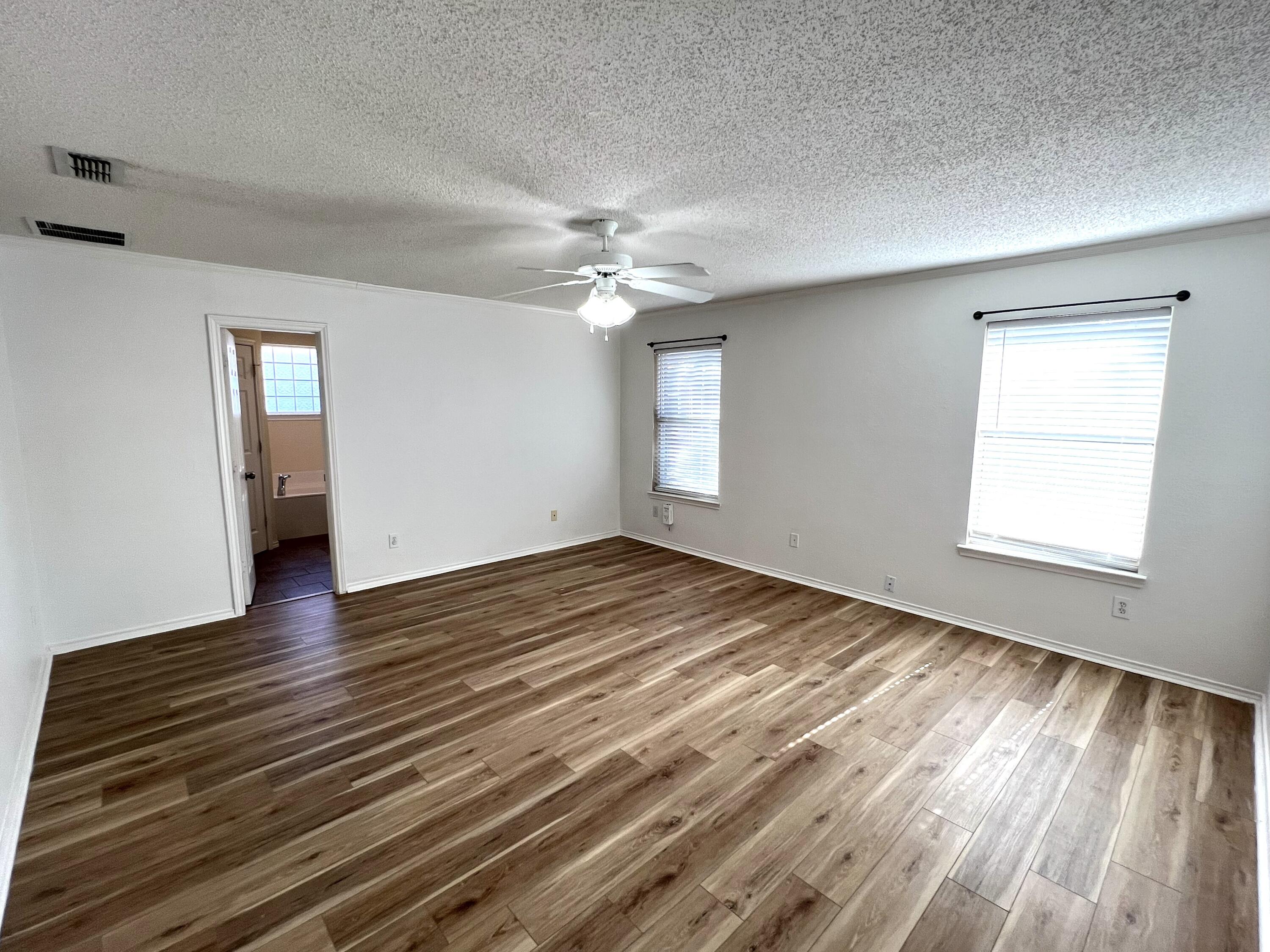 1707 76th Street Lubbock, TX 79423 - Photo 13 of 19 wooden floor in an empty room with a window