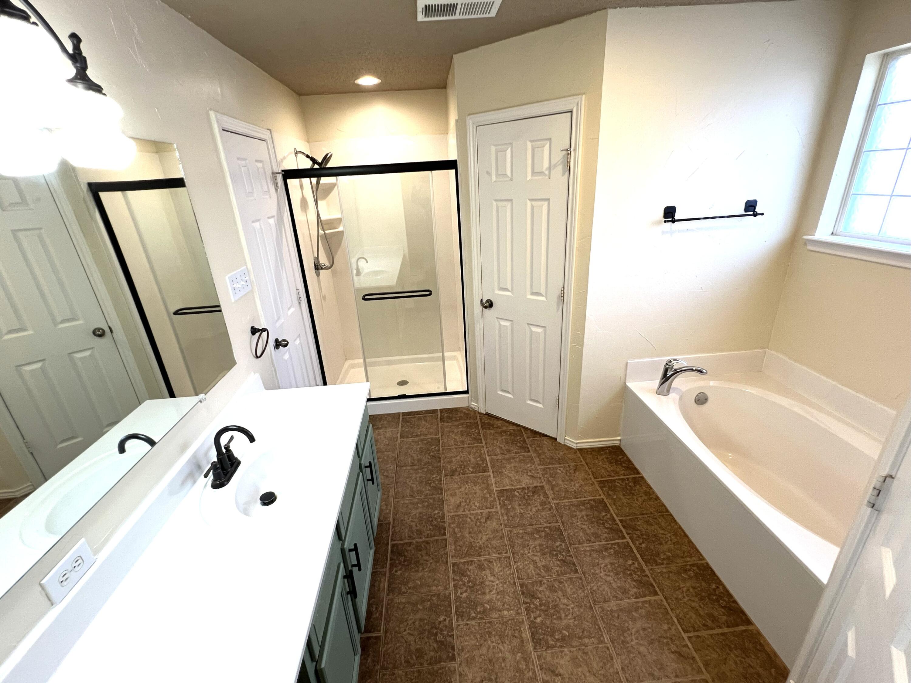1707 76th Street Lubbock, TX 79423 - Photo 15 of 19 a bathroom with a tub a sink and mirror