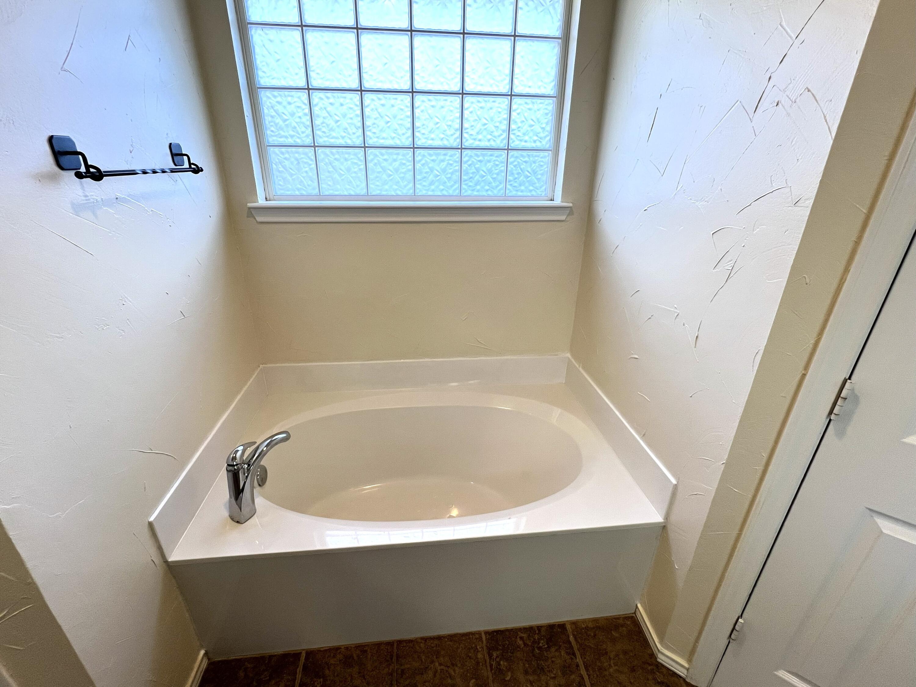 1707 76th Street Lubbock, TX 79423 - Photo 17 of 19 a bathroom with a sink and a bathtub