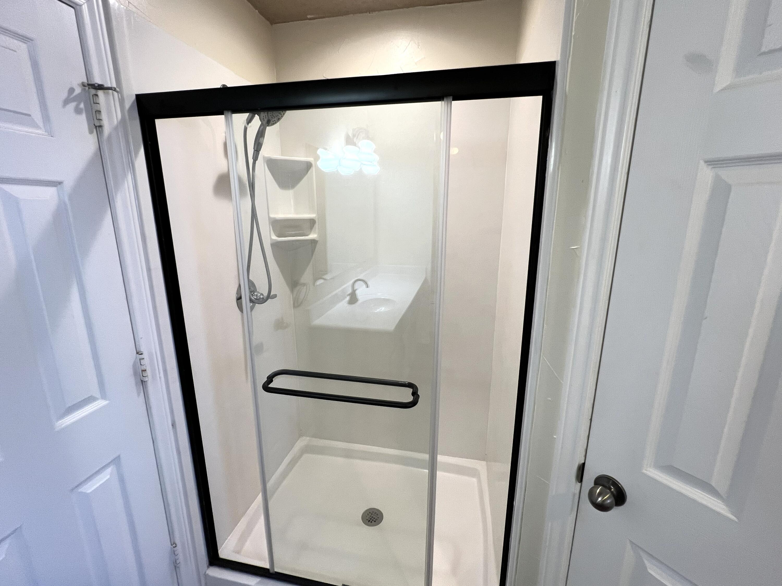 1707 76th Street Lubbock, TX 79423 - Photo 18 of 19 a bathroom with a glass shower door and a sink
