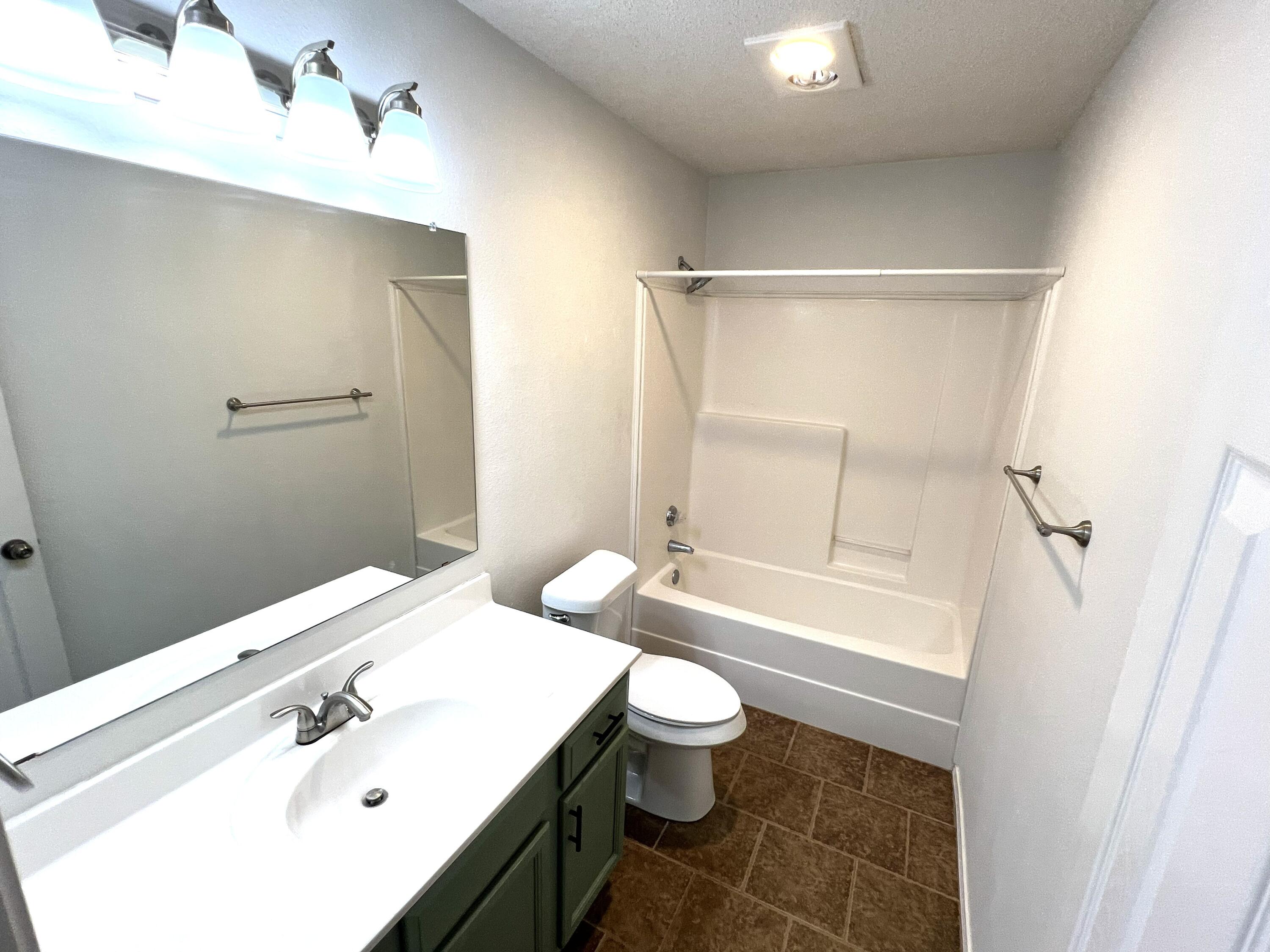 1707 76th Street Lubbock, TX 79423 - Photo 6 of 19 a bathroom with a sink a toilet and a bathtub