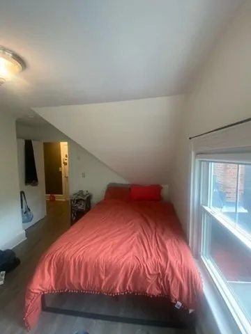a bed sitting in a bedroom next to a window