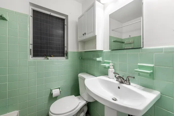 a bathroom with a sink a toilet and mirror