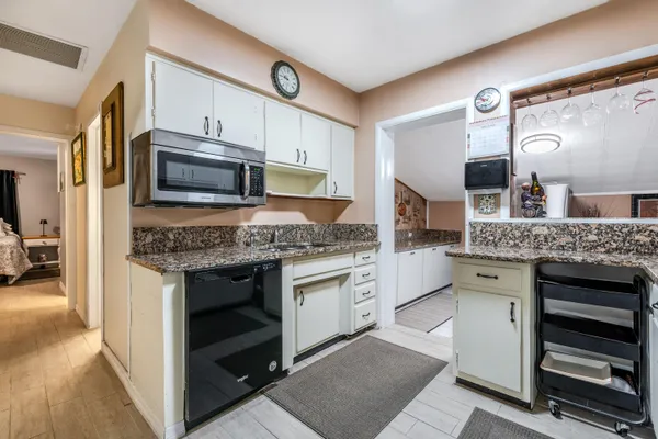 a kitchen with granite countertop cabinets stainless steel appliances and a counter space