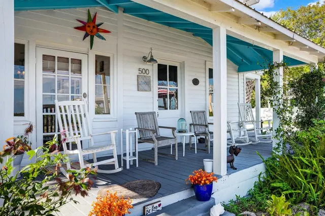 a view of a dining room with furniture a chandelier and wooden floor