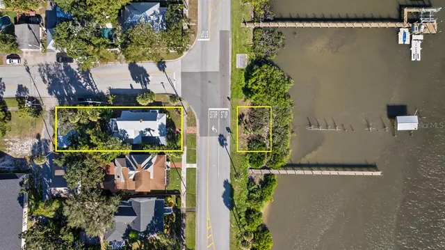 a view of a lake with a bench and trees in the background