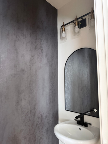 774 West 480 South American Fork, UT 84003 - Photo 31 of 76 Modern powder room featuring a textured accent wall, black arched mirror, and a contemporary vanity light fixture with clear glass shades