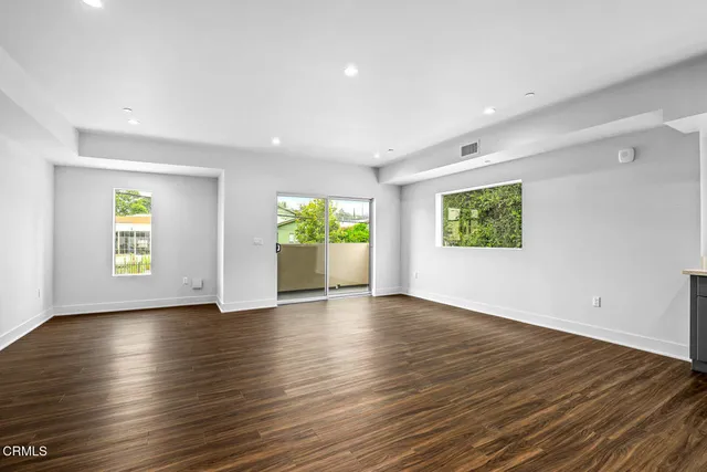 an empty room with window and wooden floor