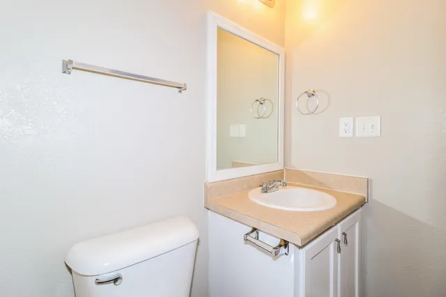 a bathroom with a sink toilet and a mirror