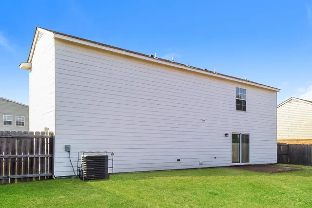 a view of backyard with barbeque grill and wooden fence