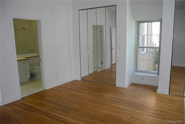 a bedroom with a bed and a lamp with wooden floor