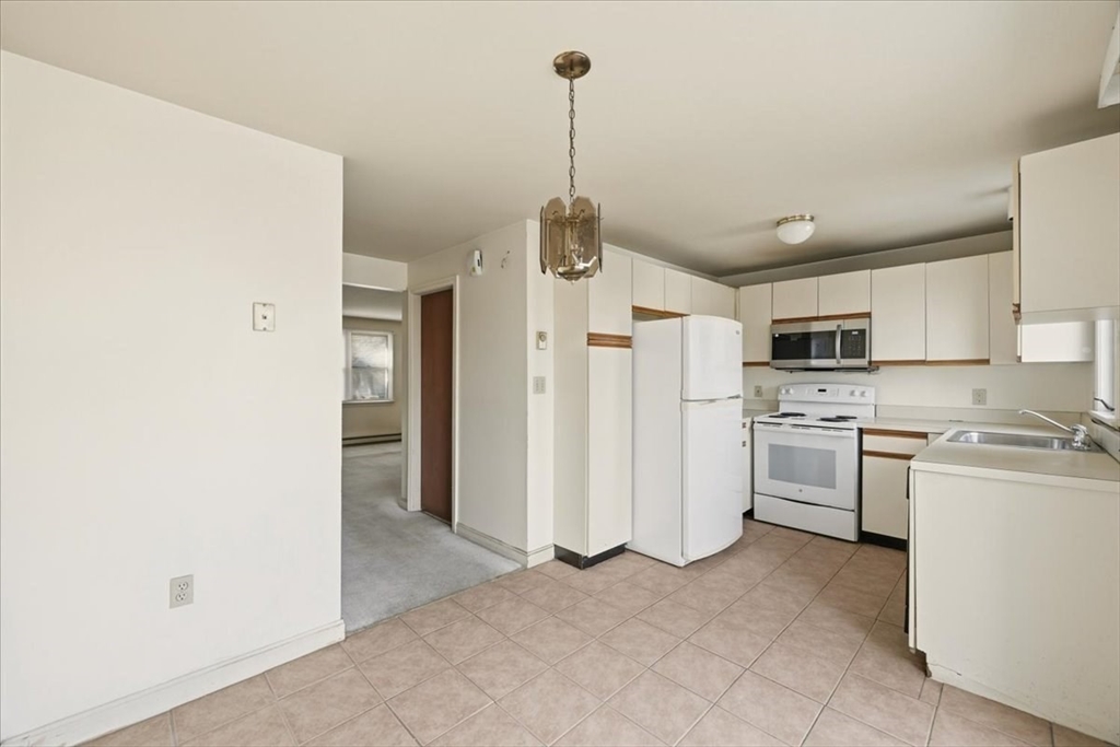 87 Victoria Heights Road, Unit 87 Boston, MA 02136 - Photo 15 of 32 a kitchen with white cabinets and stainless steel appliances